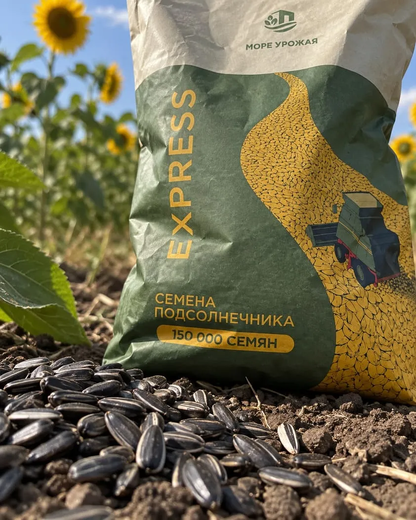 Семена подсолнечника на земле рядом с мешком «Море урожая» EXPRESS